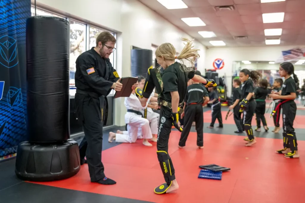 Girl Practices Kicking With Her Instructor at Youth Karate Championships in Clermont, Florida