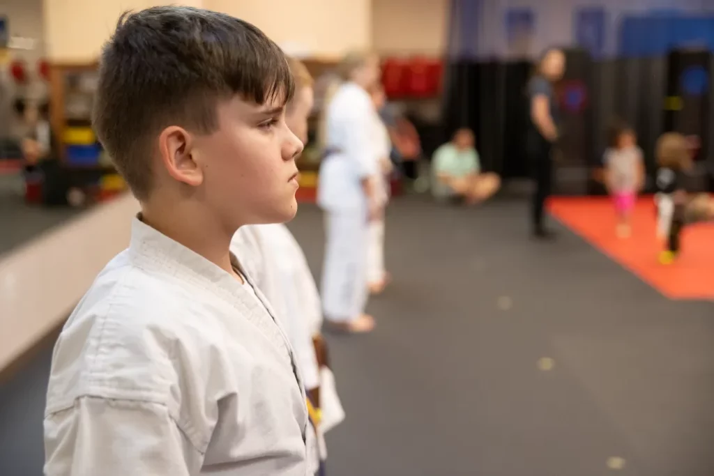 Boy Focused Standing in Line With Other Kids Behind During the Children's Black Belt Program in Arvada